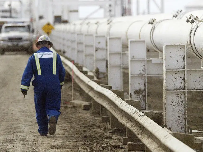 Danielle Smith i Alberta składają Markowi Carneyowi propozycję nie do odrzucenia. 1 A worker walks along a pipeline